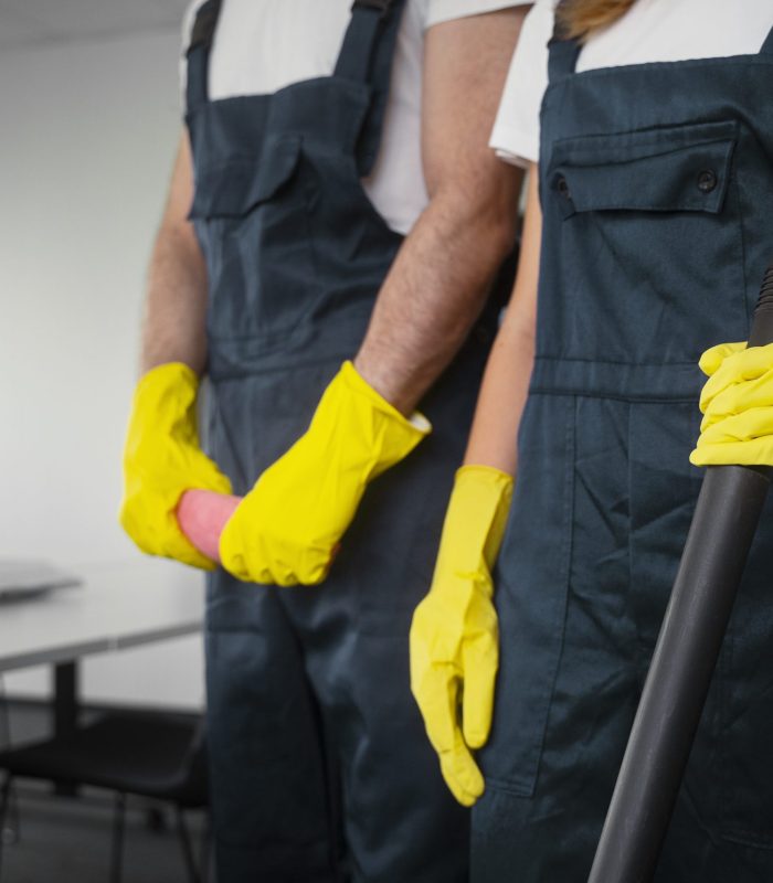 Reinigungsteam mit Besen und Gummihandschuhen bei der Gebäudereinigung